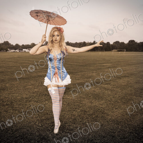 A young woman wearing a laced basque and frilly bloomers, striped stockings and… A young woman wearing a laced basque and frilly bloomers, striped stockings and…