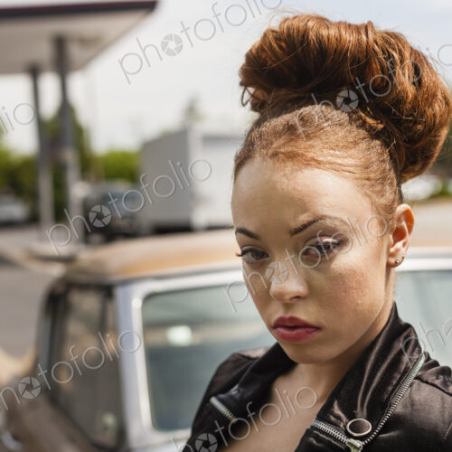 A young woman wearing makeup and a severe expression in a leather jacket. A young woman wearing makeup and a severe expression in a leather jacket.