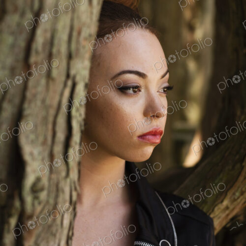A young woman wearing makeup and a severe expression in a leather jacket. A young woman wearing makeup and a severe expression in a leather jacket.