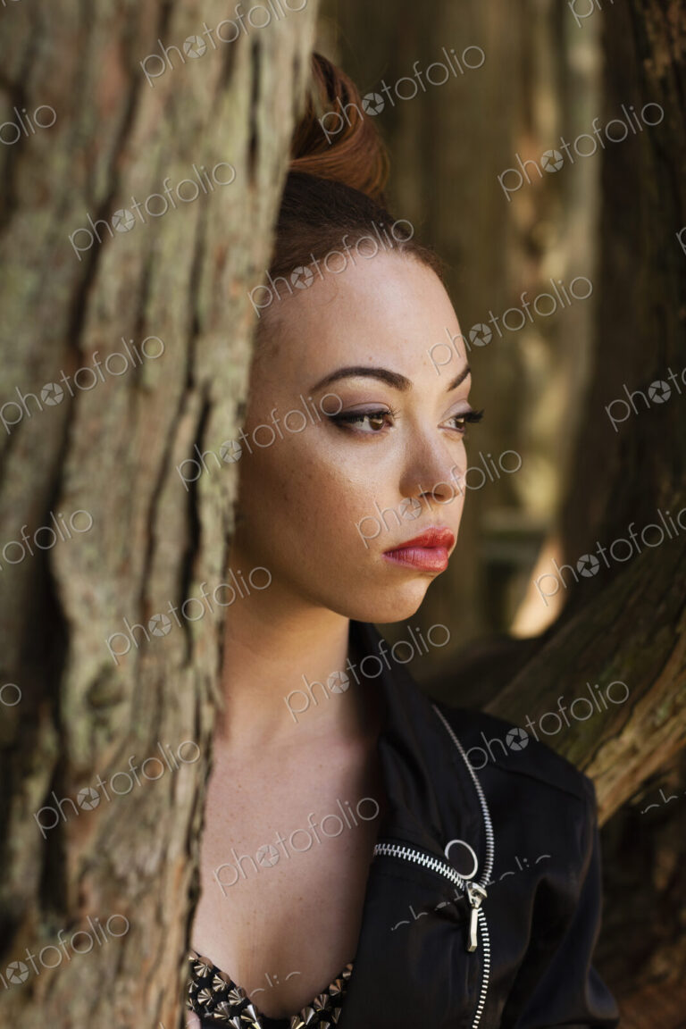 A young woman wearing makeup and a severe expression in a leather jacket.