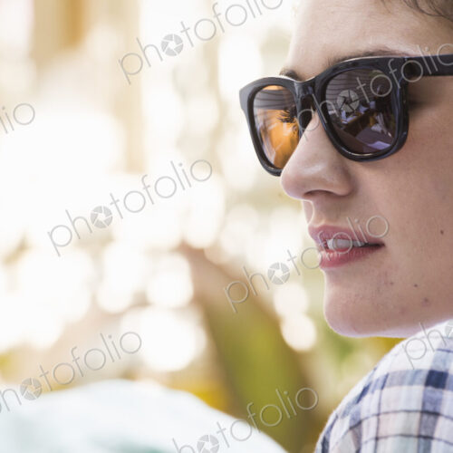A young woman wearing sunglasses turning towards a man. A young woman wearing sunglasses turning towards a man.