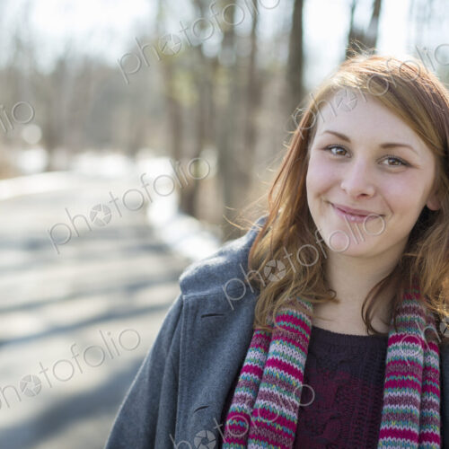 A young woman with a knitted scarf, outdoors on a snowy winter day. A young woman with a knitted scarf, outdoors on a snowy winter day.