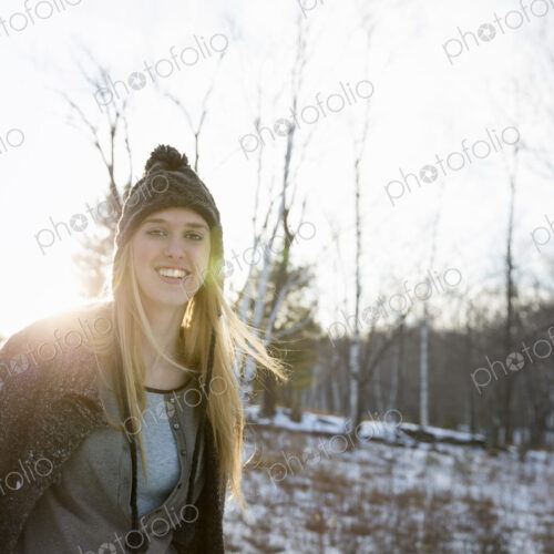 A young woman with blonde hair and a knitted woollen hat and coat. Outdoors on a… A young woman with blonde hair and a knitted woollen hat and coat. Outdoors on a…