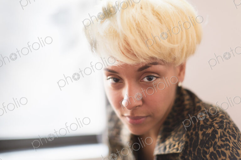 A young woman with blonde hair looking intently at the camera.