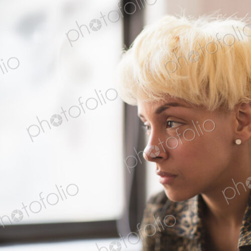 A young woman with blonde hair looking out of the window. A young woman with blonde hair looking out of the window.