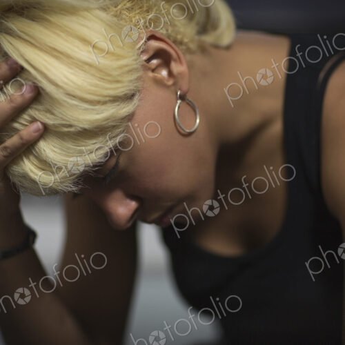 A young woman with blonde hair, with her head in her hands. A young woman with blonde hair, with her head in her hands.