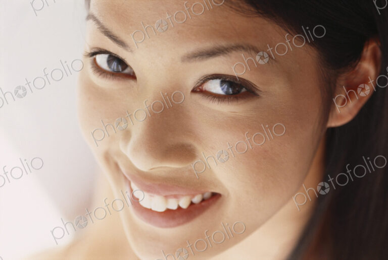 A young woman with brown eyes, smiling. Close up.