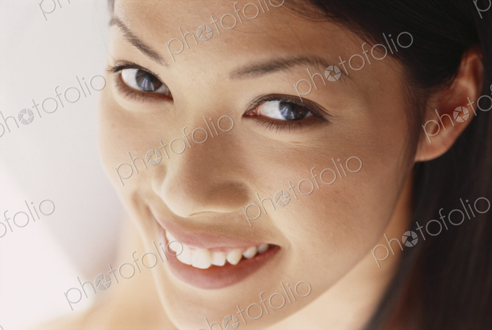 A young woman with brown eyes, smiling. Close up.