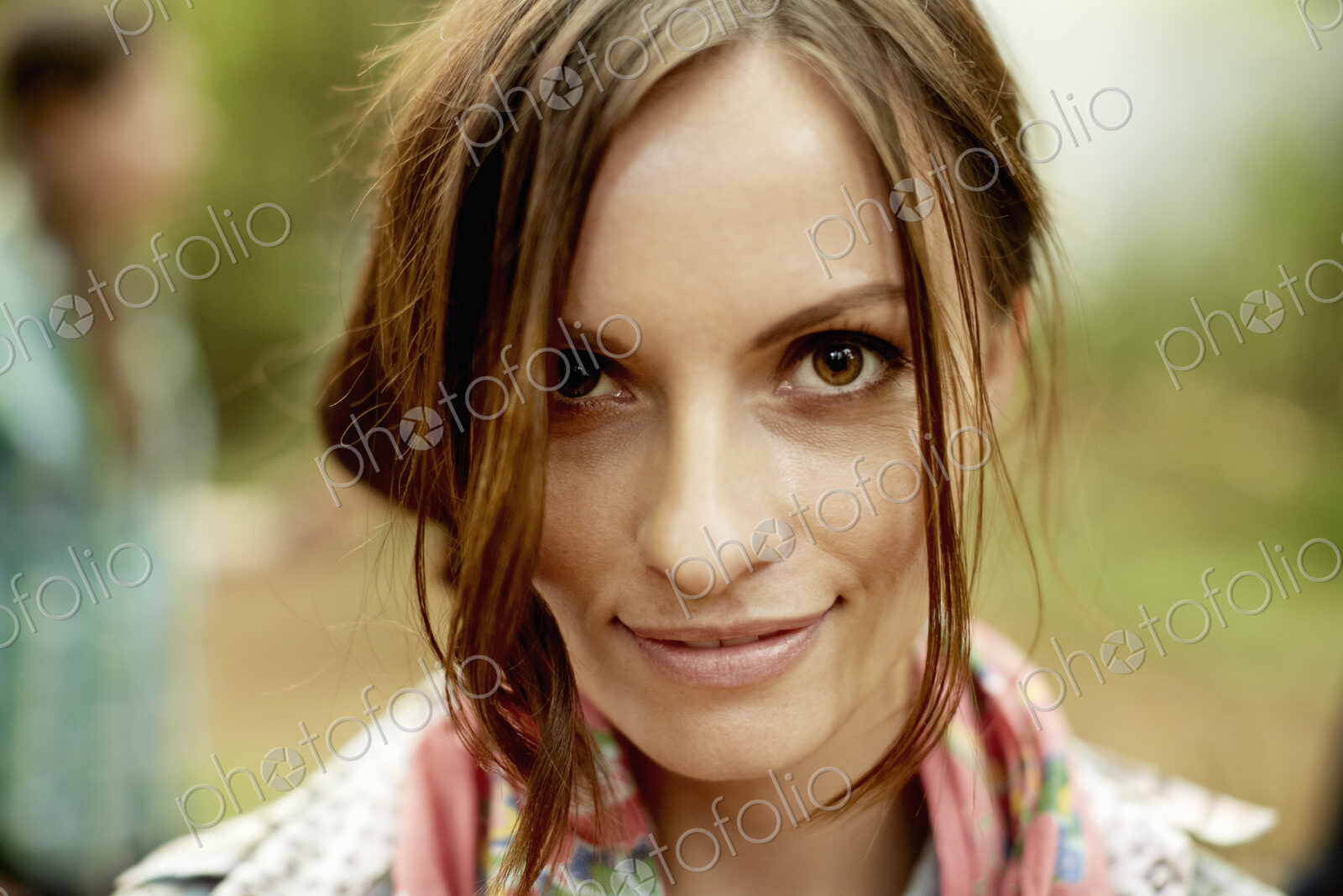 A young woman with long brown hair smiling at the camera.