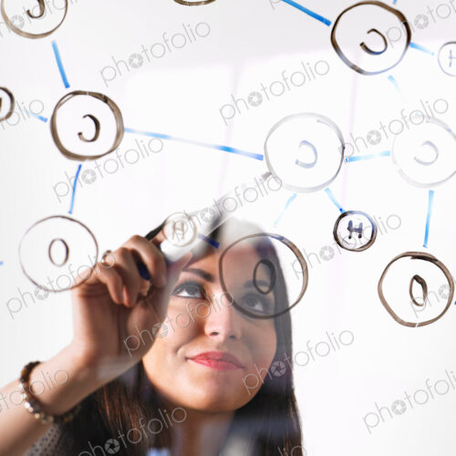 A young woman writing a chemical notation for the gas Oxygen, the molecular structure,… A young woman writing a chemical notation for the gas Oxygen, the molecular structure,…