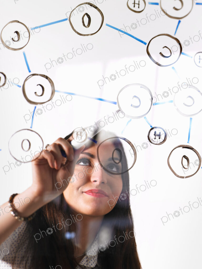 A young woman writing a chemical notation for the gas Oxygen, the molecular structure,…