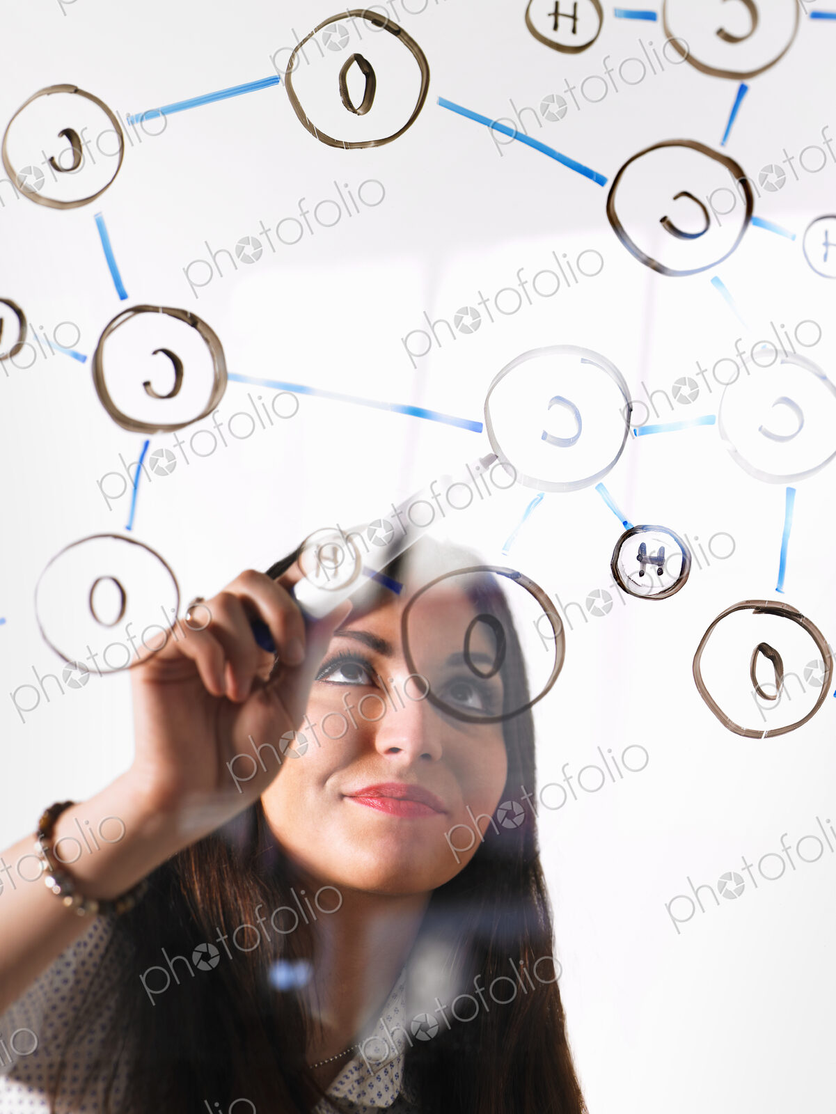 A young woman writing a chemical notation for the gas Oxygen, the molecular structure,…