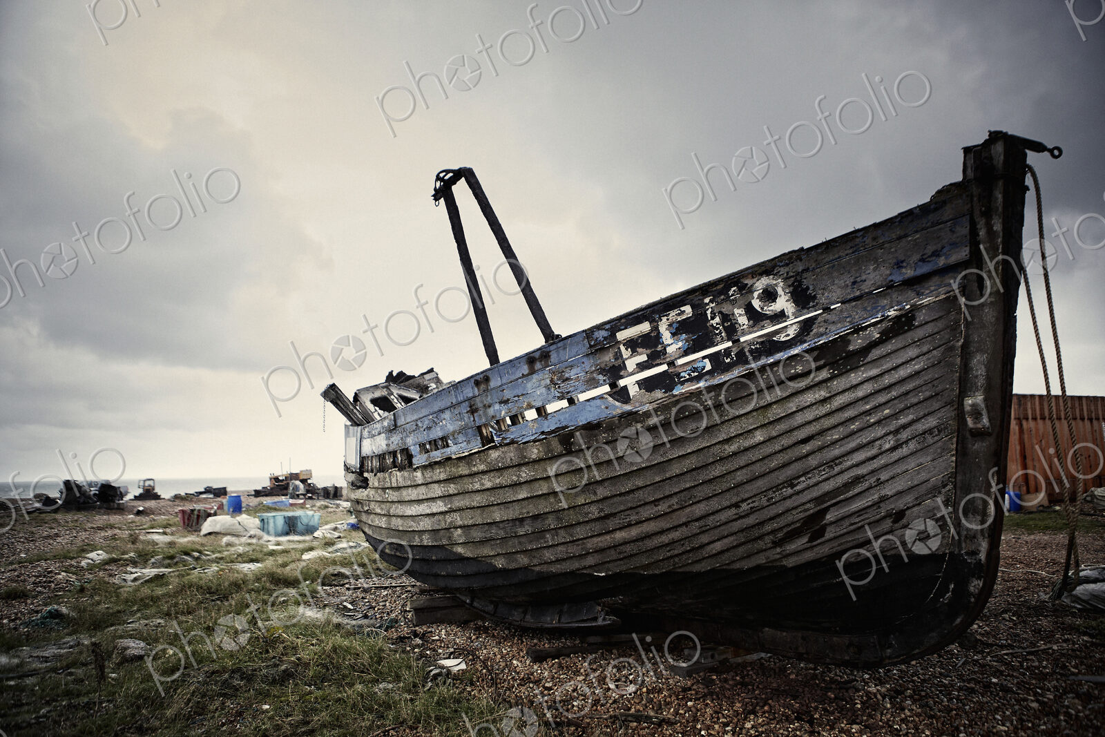 Abandoned wooden boat lying on a shingle beach.