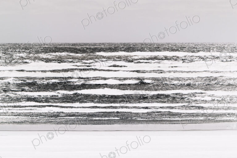 Abstract of breaking waves and moody sky at dusk