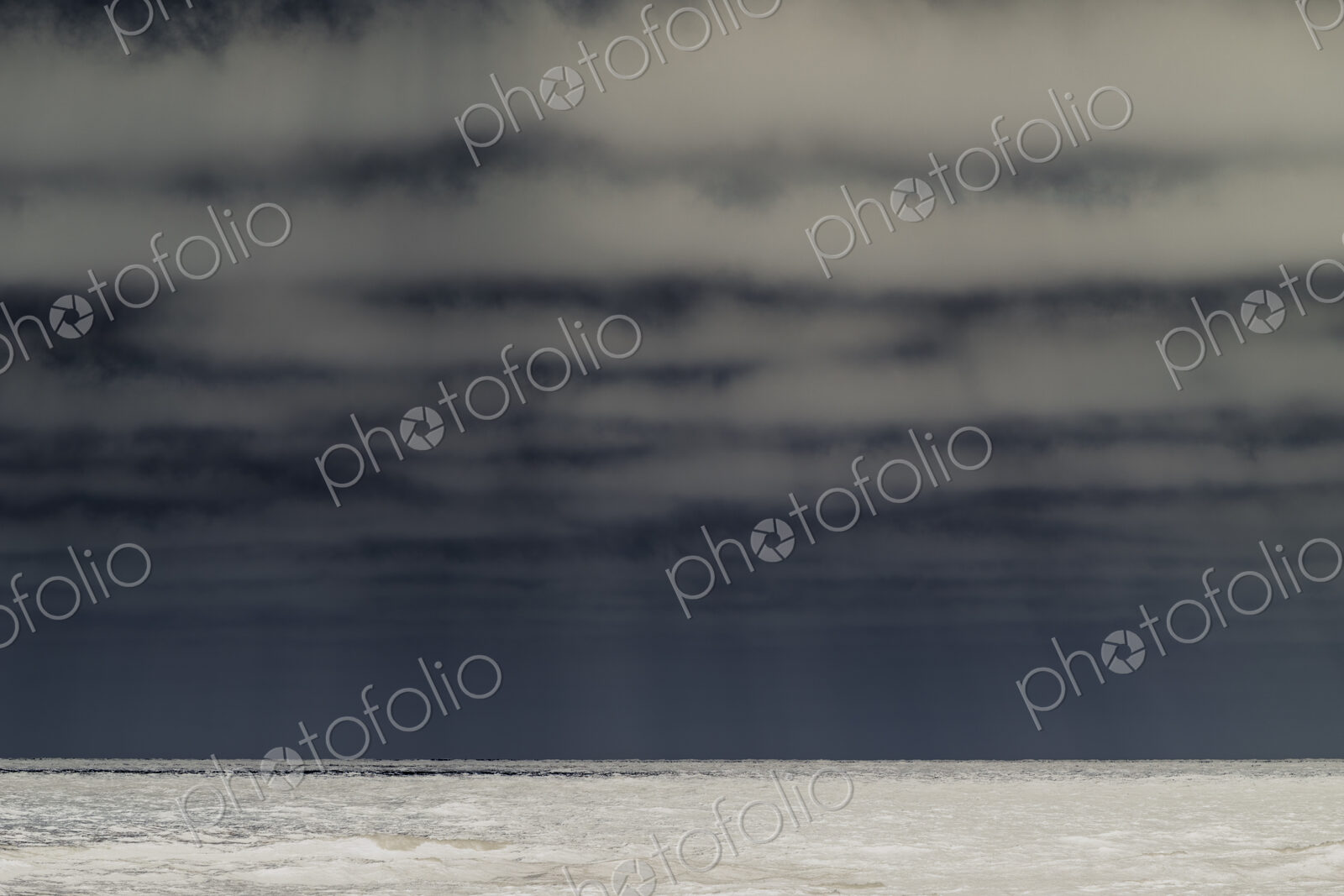 Abstract of breaking waves and moody sky at dusk
