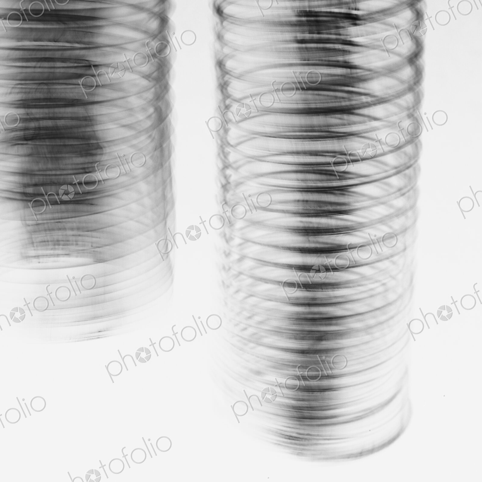 Abstract of metal coiled slinky, length of fine wire wound around and stretched, black…