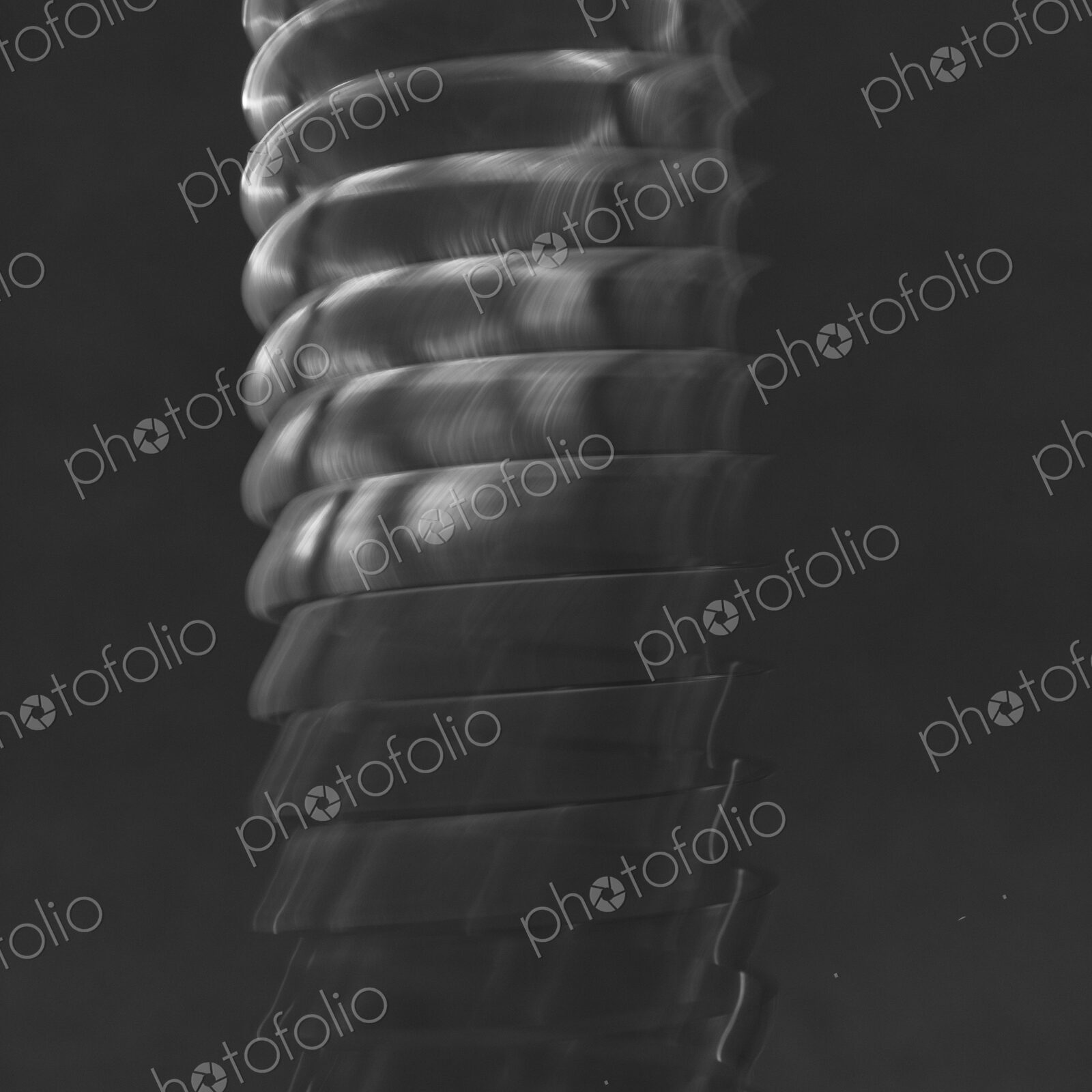 Abstract of metal coiled slinky, length of fine wire wound around and stretched,…