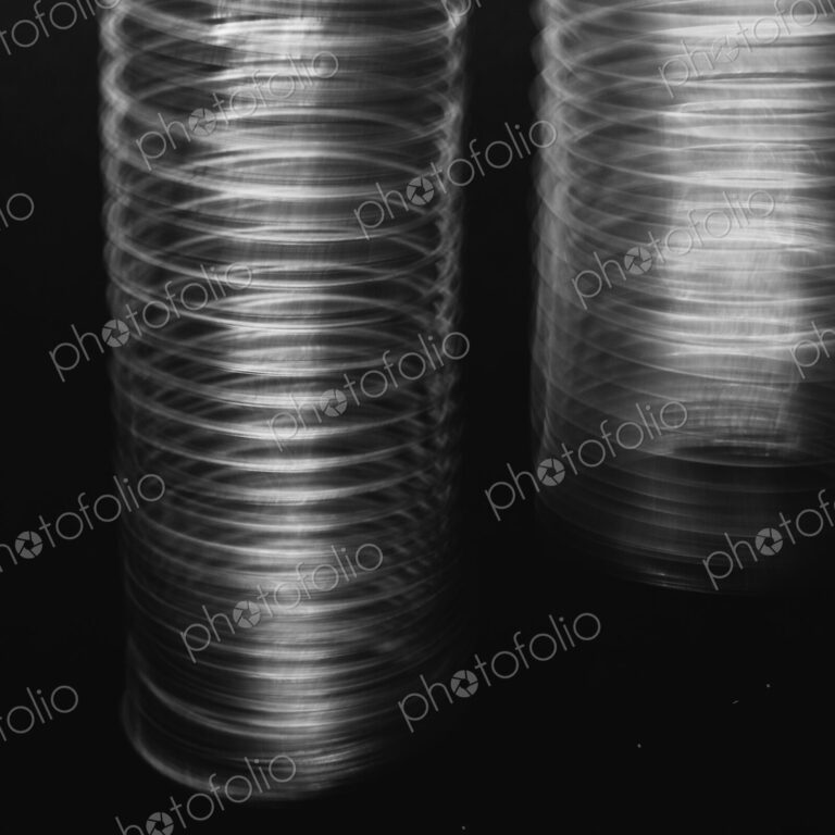 Abstract of metal coiled slinky, length of fine wire wound around and stretched,…
