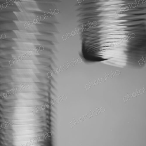 Abstract of metal coiled slinky tube, length of fine wire wound around and stretched,… Abstract of metal coiled slinky tube, length of fine wire wound around and stretched,…