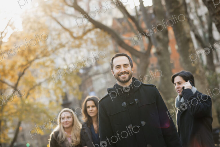 Adult group in urban park, man in front