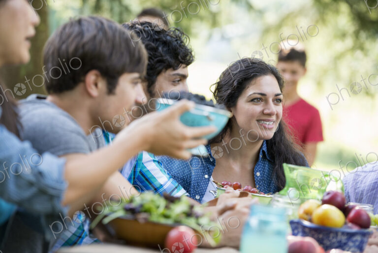 Adults and children around a table at a party in a garden.