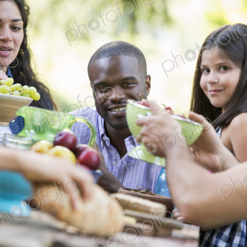 Adults and children around a table at a party in a garden.
