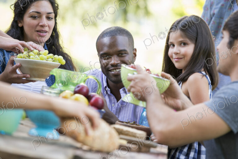 Adults and children around a table at a party in a garden.