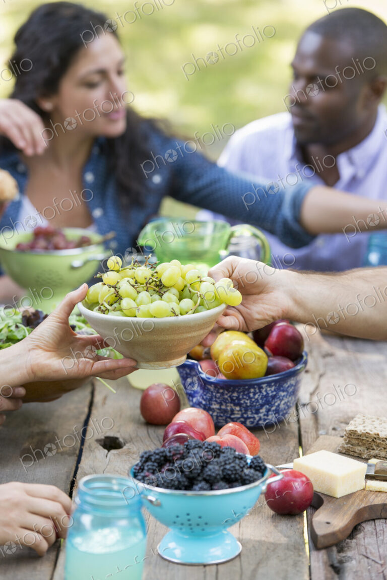 Adults and children around a table at a party in a garden.