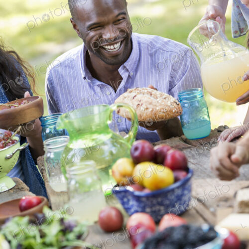 Adults and children around a table at a party in a garden.