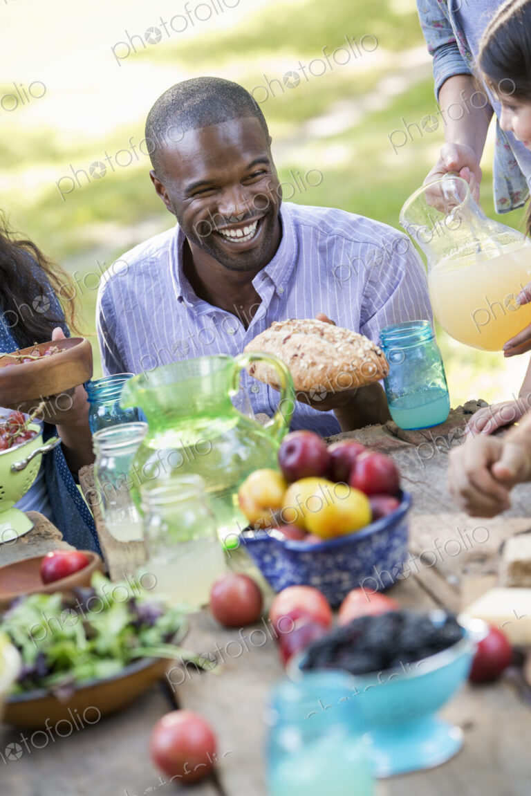 Adults and children around a table at a party in a garden.