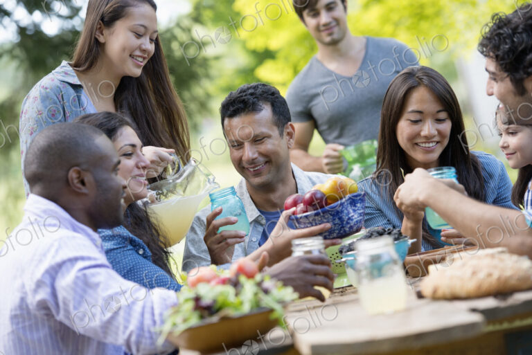 Adults and children around a table in a garden.