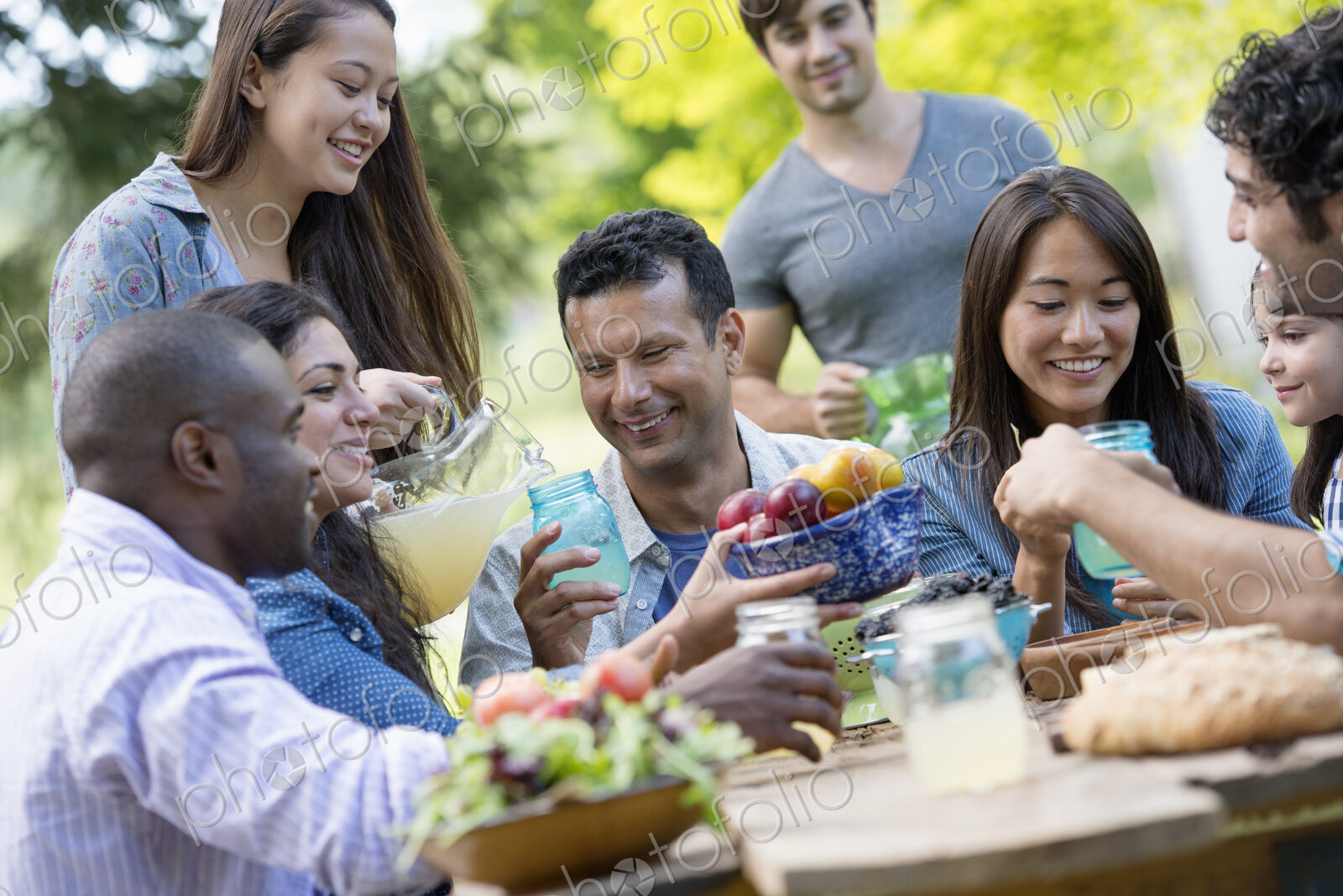 Adults and children around a table in a garden.