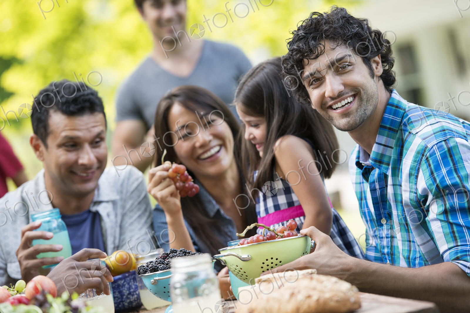 Adults and children around a table in a garden.