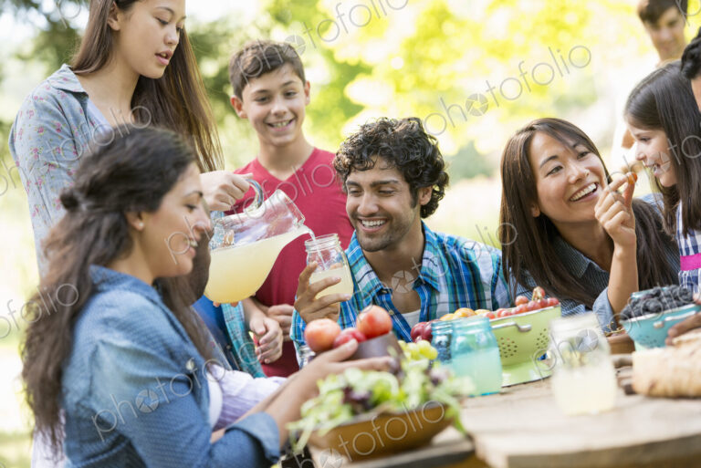Adults and children around a table in a garden.