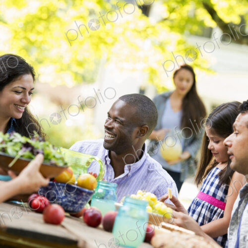 Adults and children around a table in a garden.