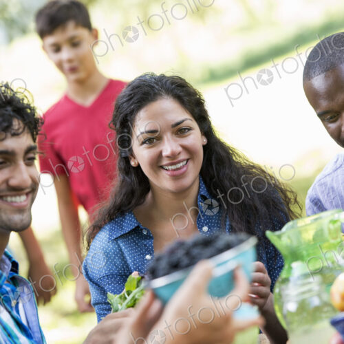 Adults and children around a table in a garden.