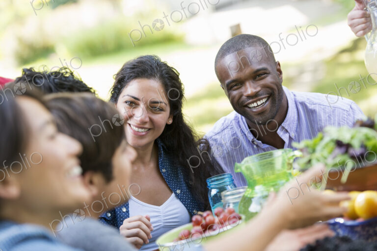 Adults and children around a table in a garden.