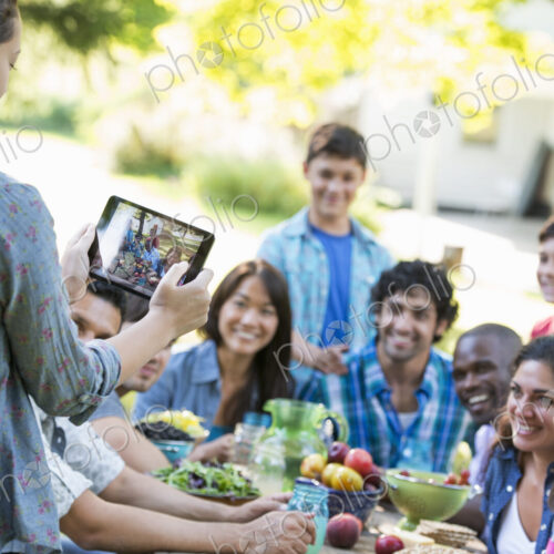 Adults and children posing for a photograph at a summer party.