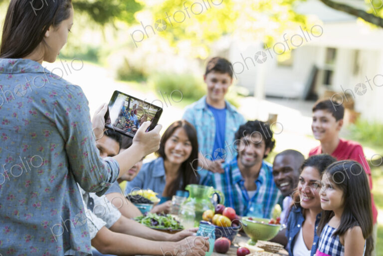 Adults and children posing for a photograph at a summer party.