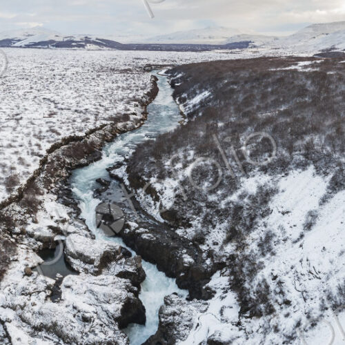 Aerial View of Barnafoss on the river Hvítá, white water cascading down a narrow gorge…