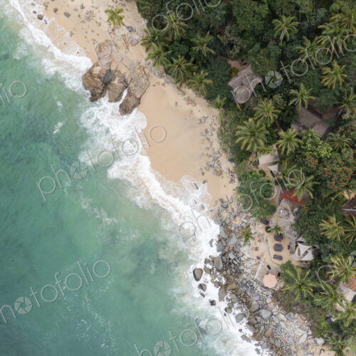 Aerial View of Casitas Marika beach, small beach huts and a thick cover of palm trees… Aerial View of Casitas Marika beach, small beach huts and a thick cover of palm trees…