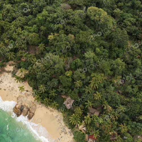 Aerial View of Casitas Marika beach, small beach huts and a thick cover of palm trees… Aerial View of Casitas Marika beach, small beach huts and a thick cover of palm trees…