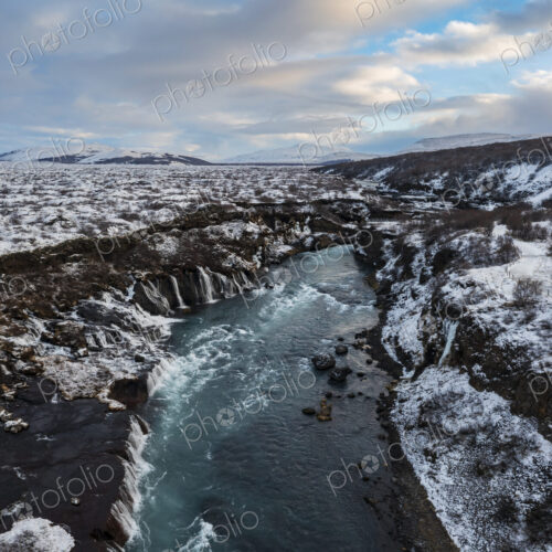 Aerial View of Hraunfossar waterfalls on the Hvita River, the water flowing from the…
