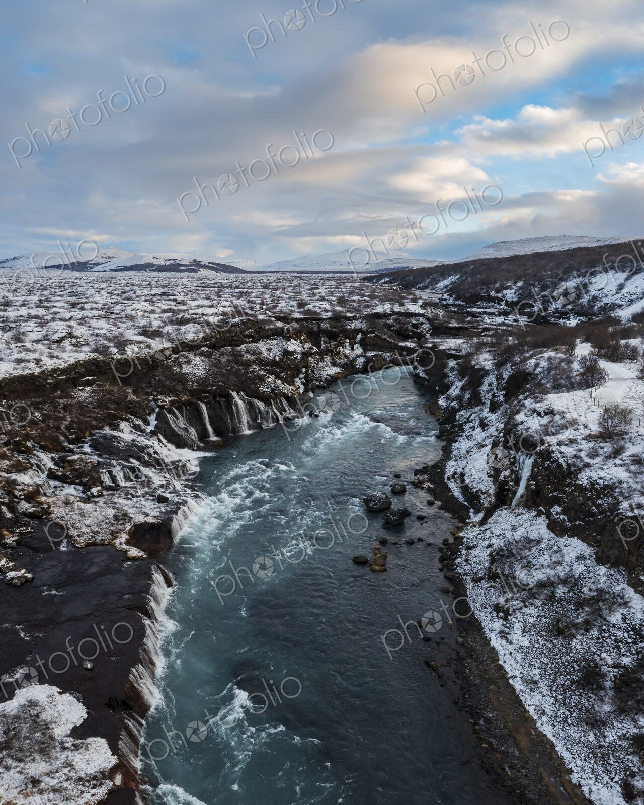 Aerial View of Hraunfossar waterfalls on the Hvita River, the water flowing from the…