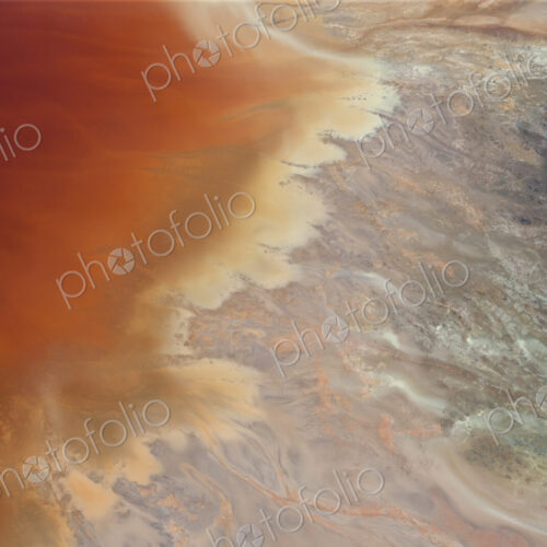 Aerial shot of oxidized iron minerals in water in old mining area.