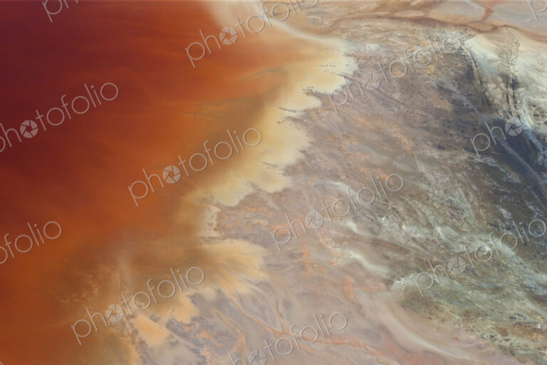 Aerial shot of oxidized iron minerals in water in old mining area.