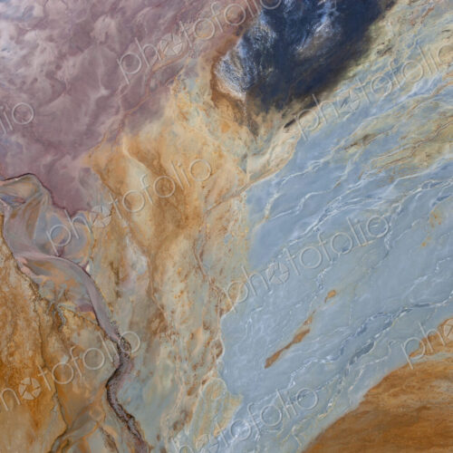 Aerial shot of oxidized iron minerals in water in old mining area.