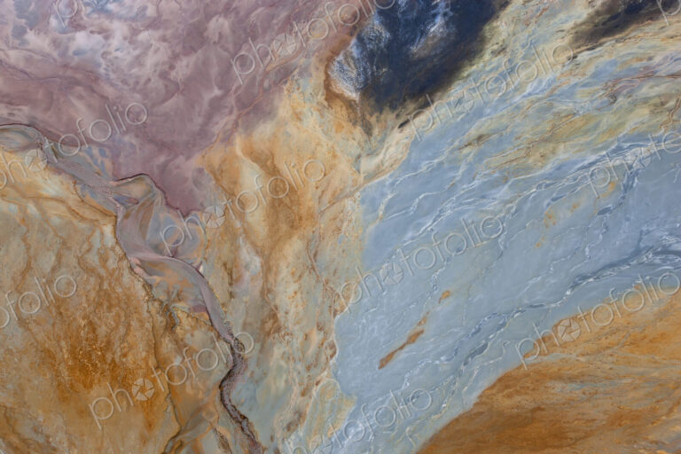 Aerial shot of oxidized iron minerals in water in old mining area.