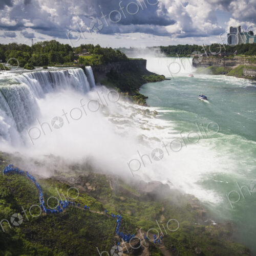 Aerial view of Niagara Falls with skyscrapers beyond.