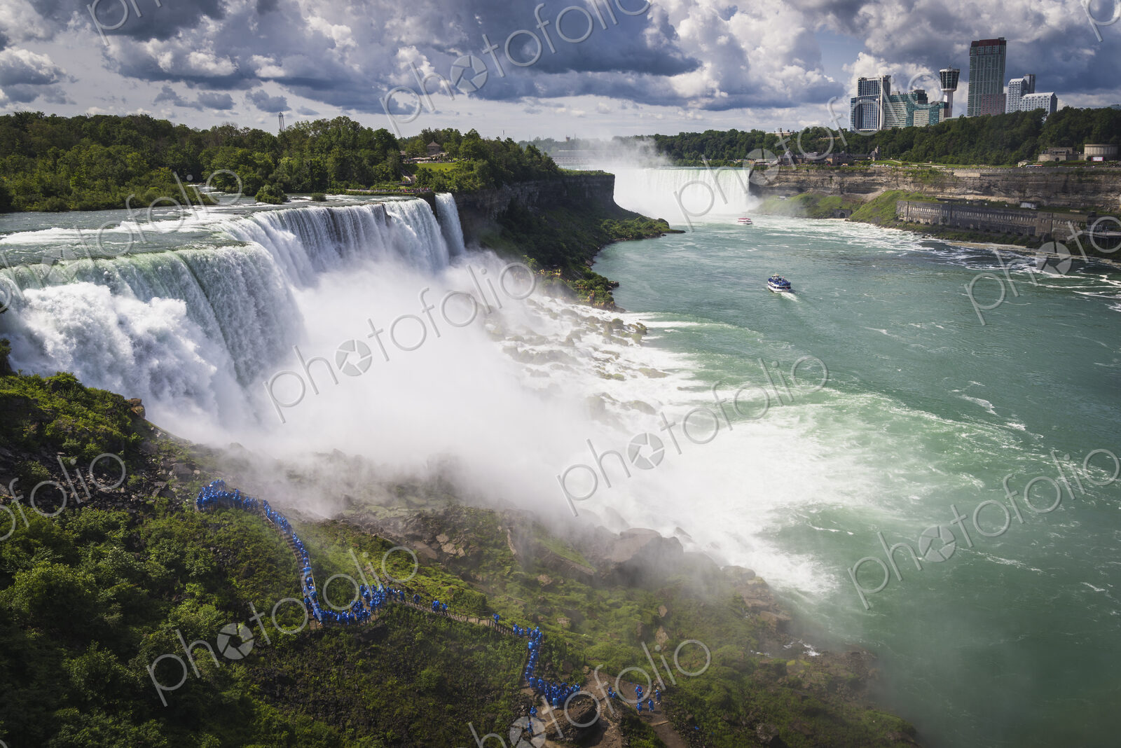 Aerial view of Niagara Falls with skyscrapers beyond.